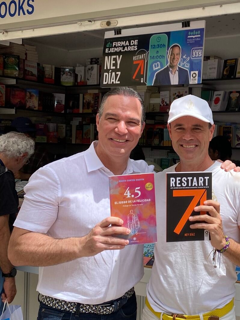 Ney Díaz y Mario Cortés posando con el libro 4.5 el juego de la felicidad