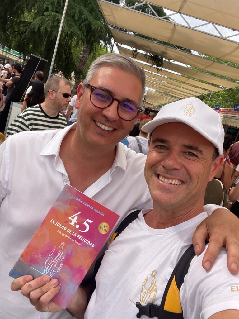 Roger Domingo y Mario Cortés posando con el libro 4.5 el juego de la felicidad